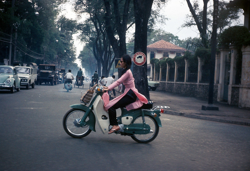 Cô gái với chiếc áo dài màu hồng trên Ngã tư Hồng Thập Tự & Công Lý. Bên trái là Dinh Độc Lập, bên phải là trường Lê Quí Đôn - Sài Gòn 1969