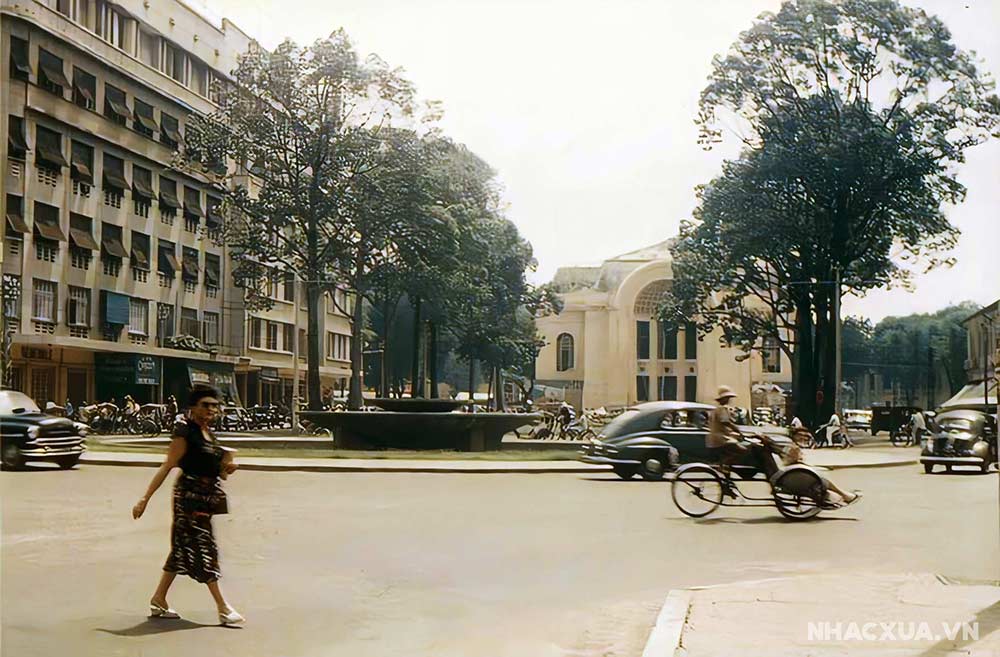 Ngã Tư Lê Lợi - Nguyễn Huệ năm 1955, góc chụp từ thương xá TAX. Phía trước là Opera House với bùng binh Bồn Kèn và công trường Lam Sơn. Bên trái là Eden.