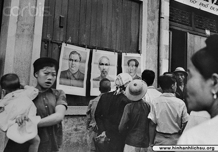 Người dân miền Bắc Việt Nam với chân dung của Hồ Chí Minh và Mao Trạch Đông được dán bên ngoài đường phố Hà Nội.